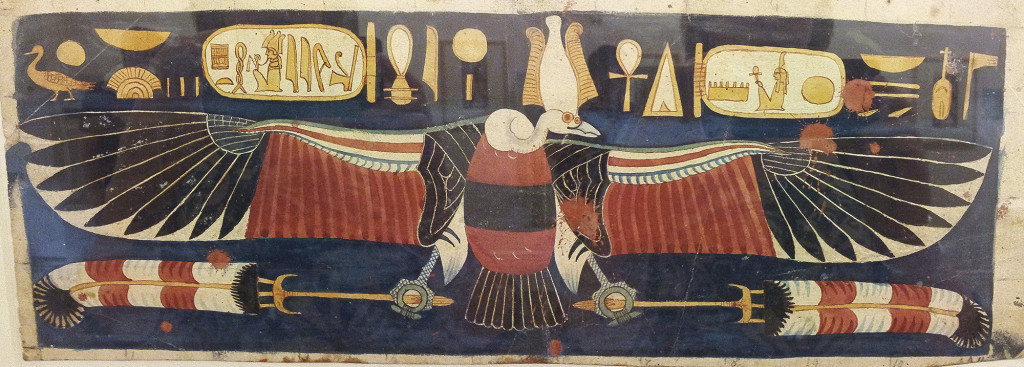 Nekhbet as a vulture, with outstretched wings and wearing an Atef crown. She has hieroglyphs either side of her, running along above her wings