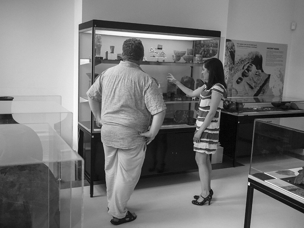 Gina and Roland standing in front of a three-shelved display case