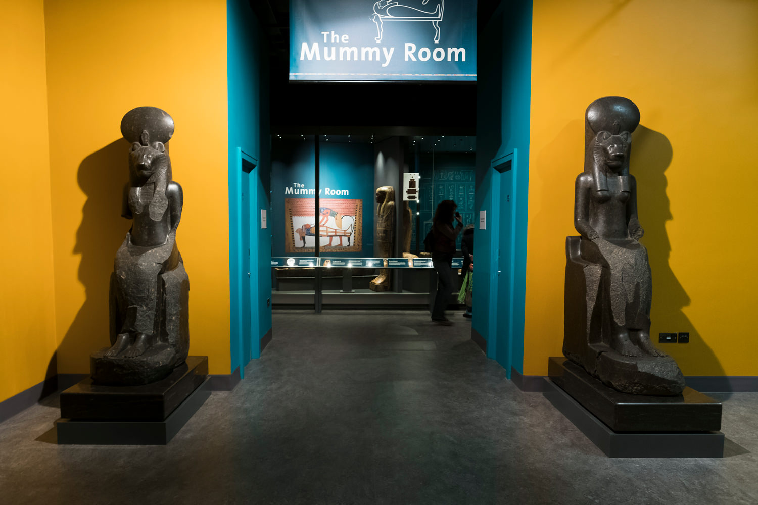 The entrance to the mummy room. The museum's two large, stone statues of the goddess Sekhmet are either side of the doorway.