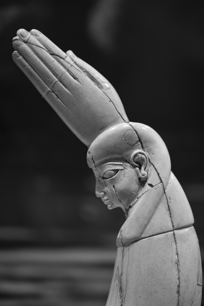 The top half of an ancient Egyptian ivory clapper, carved into the shape of a head and hand