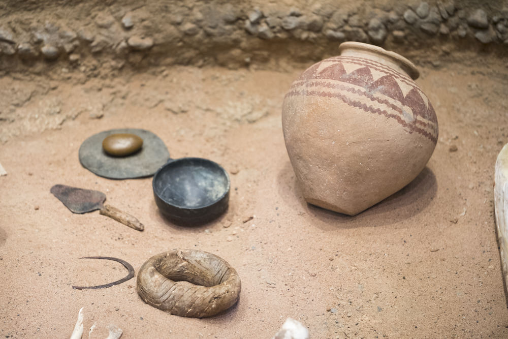 Predynastic Egyptian pots and a pot stand sitting in sand