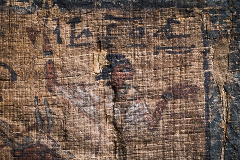 A close-up of an ancient Egyptian person painted on papyrus