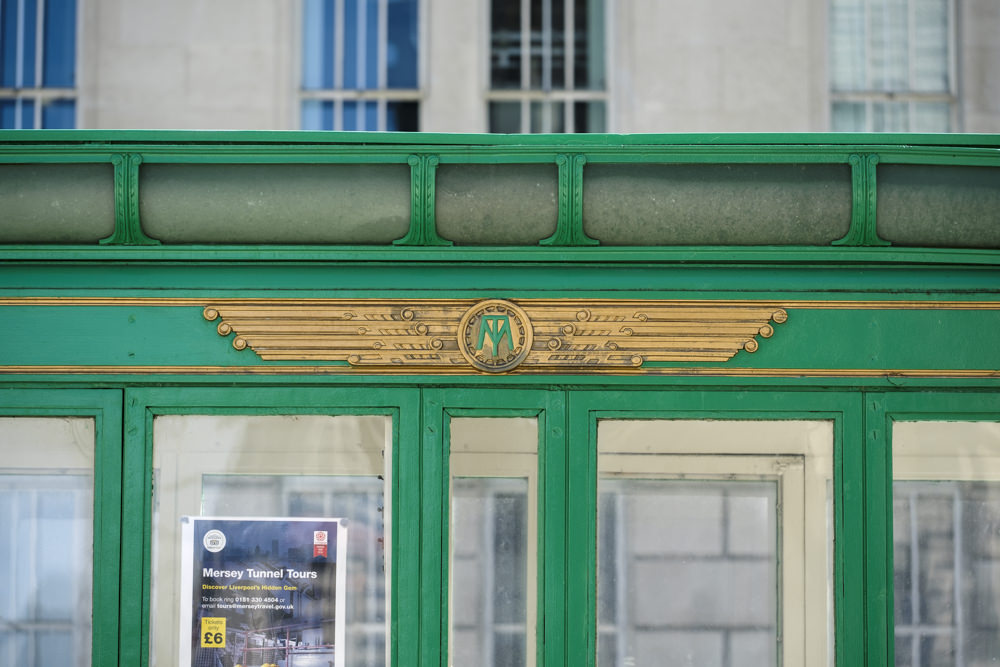 A green and gold toll booth with a winged emblem on the side