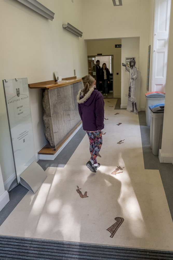 A girl approaching the door to a museum