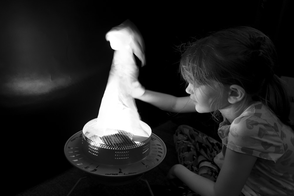 A girl playing with a pretend flame