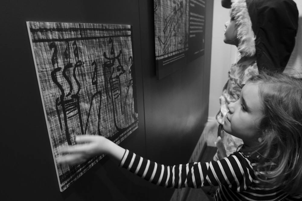 Two girls looking at a photo on a wall