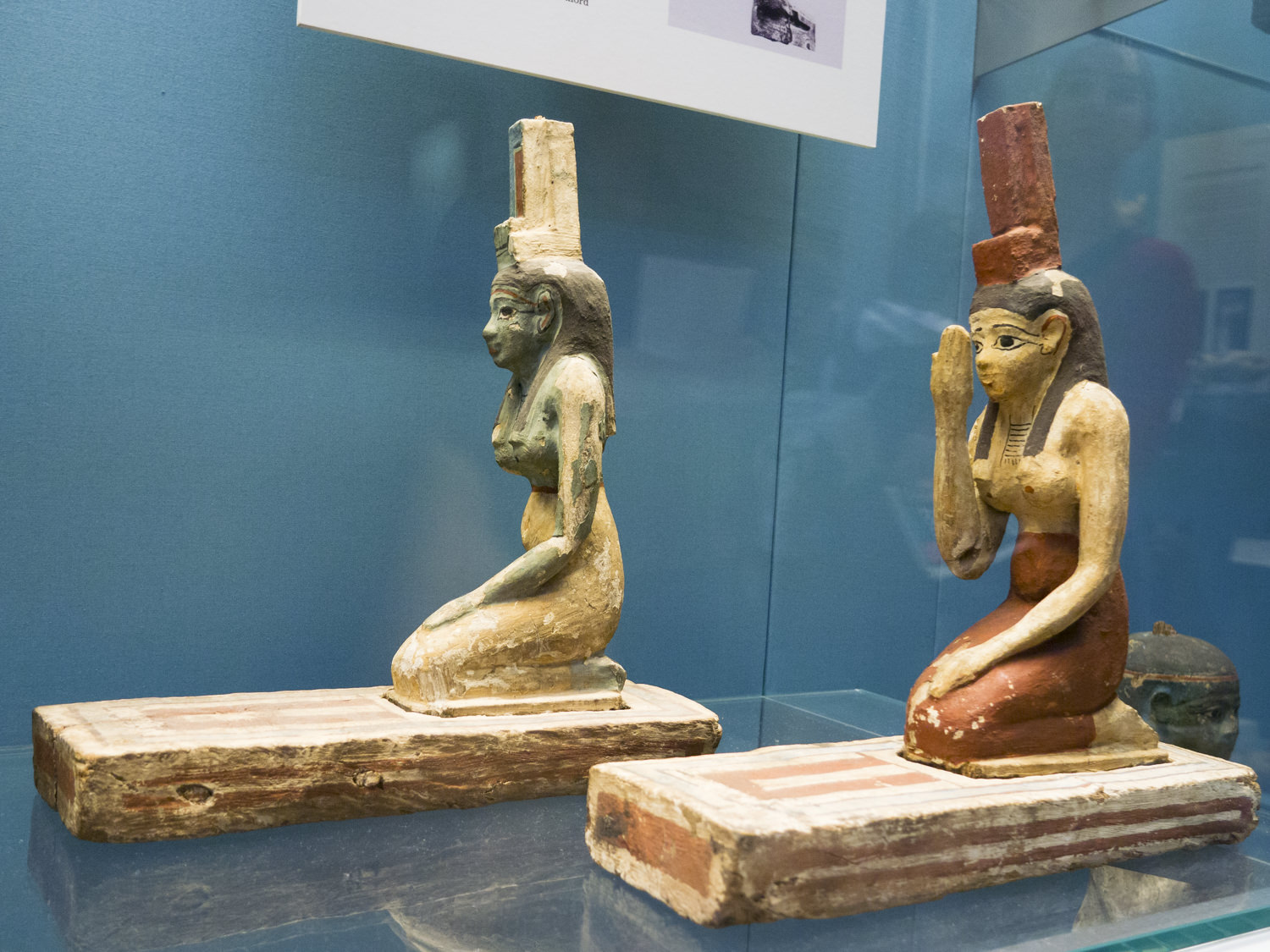 Two statues of Isis, kneeling down, with a throne emblem on her head