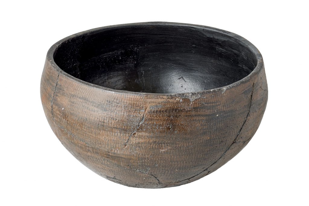 A wide, ceramic, plain ancient Egyptian bowl with a ripple burnish