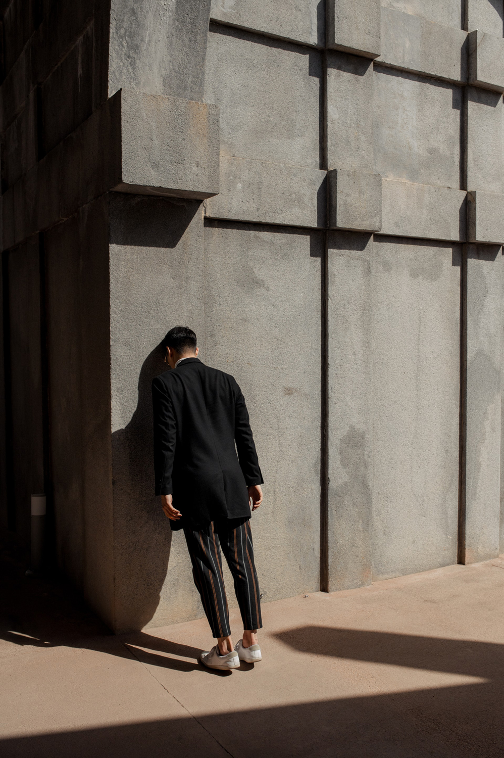 a man with his head against a wall