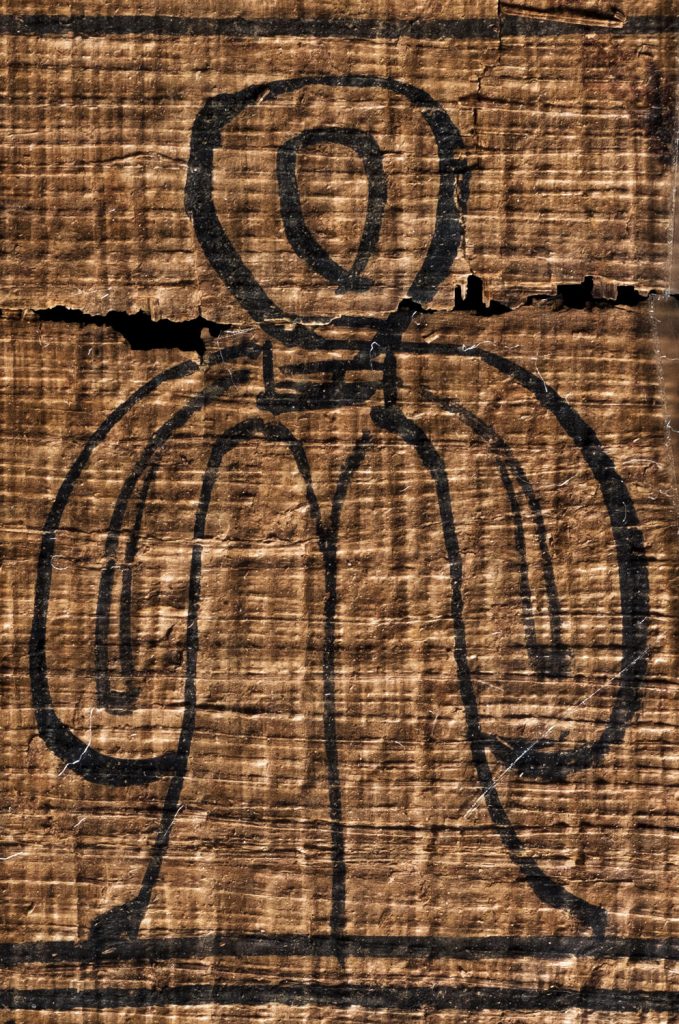 an egyptian tyet (isis knot) on papyrus