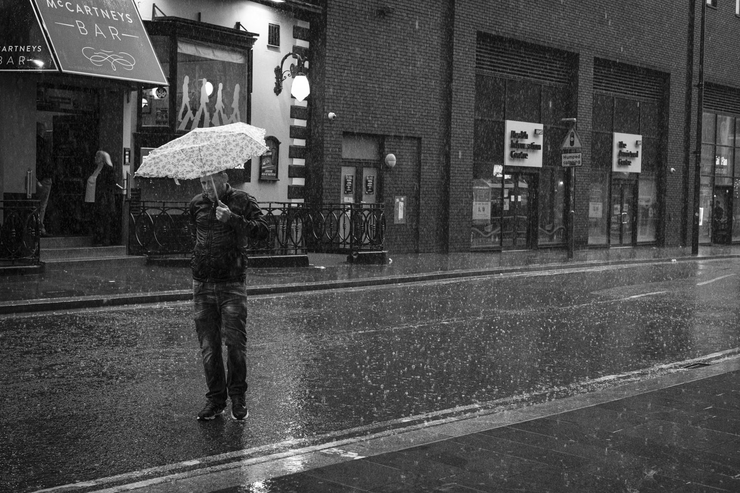 a man in the rain under a broken umbrella