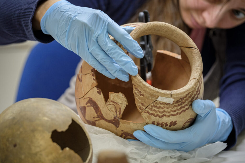 a conservator working an ancient egyptian pot