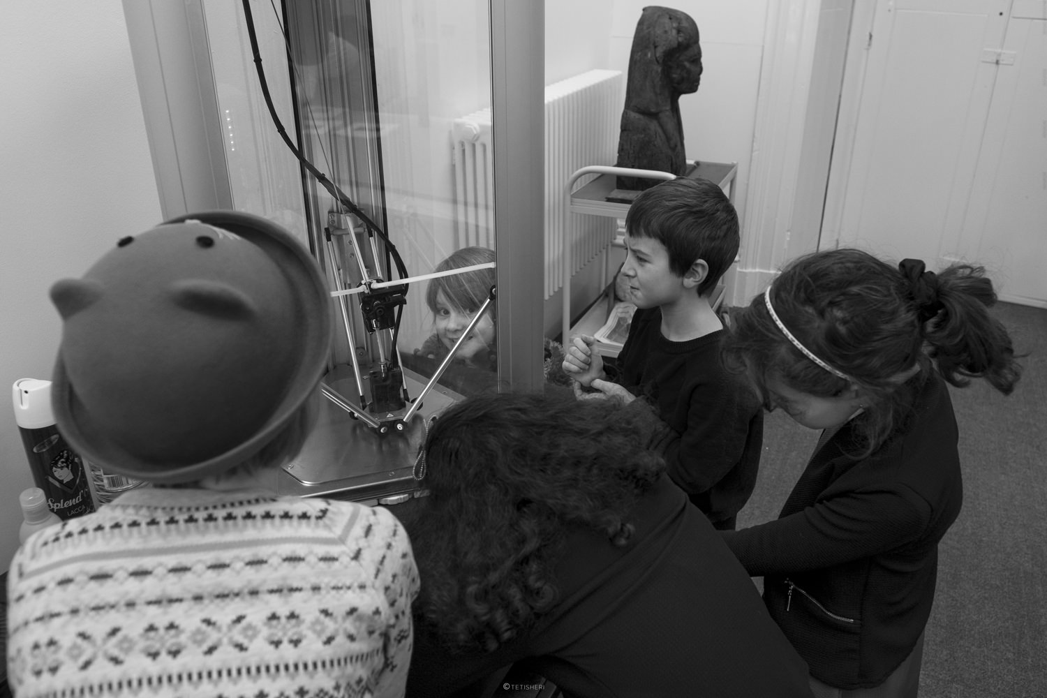 some children looking at a 3d printer