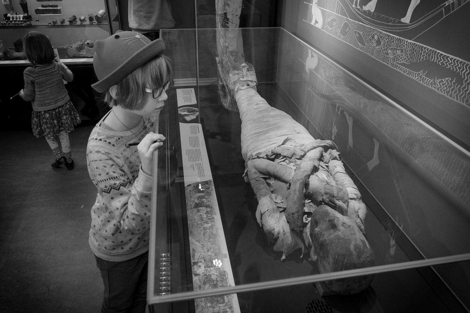 a girl looking at an egyptian mummy