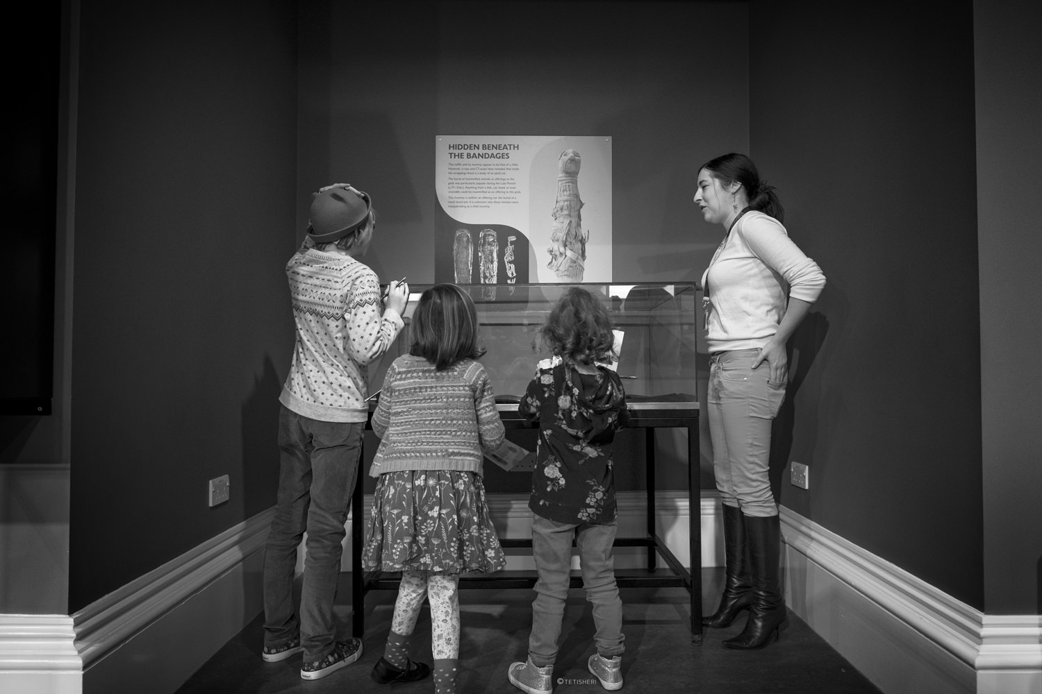 a curator with children looking at egyptian artefacts