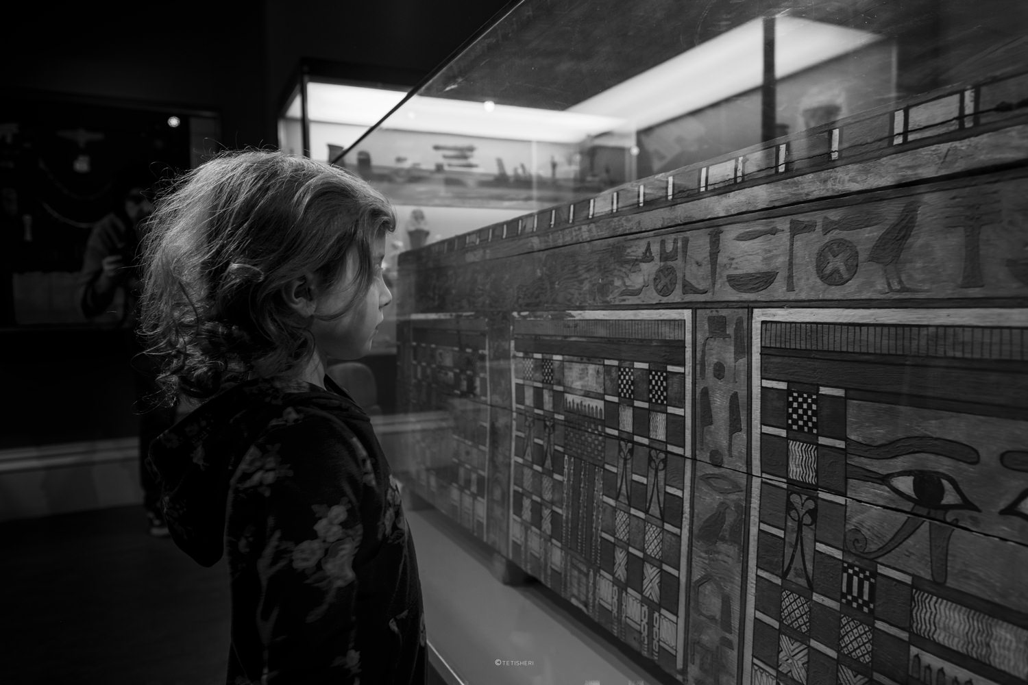 a girl looking at an ancient egyptian coffin