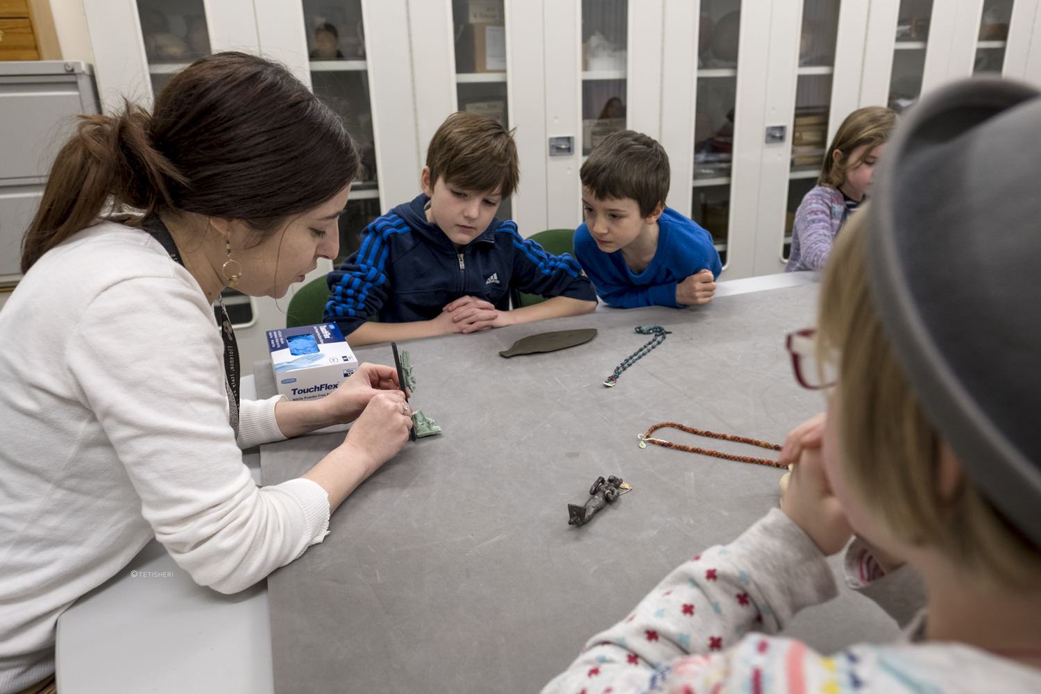 a curator with children looking at egyptian artefacts