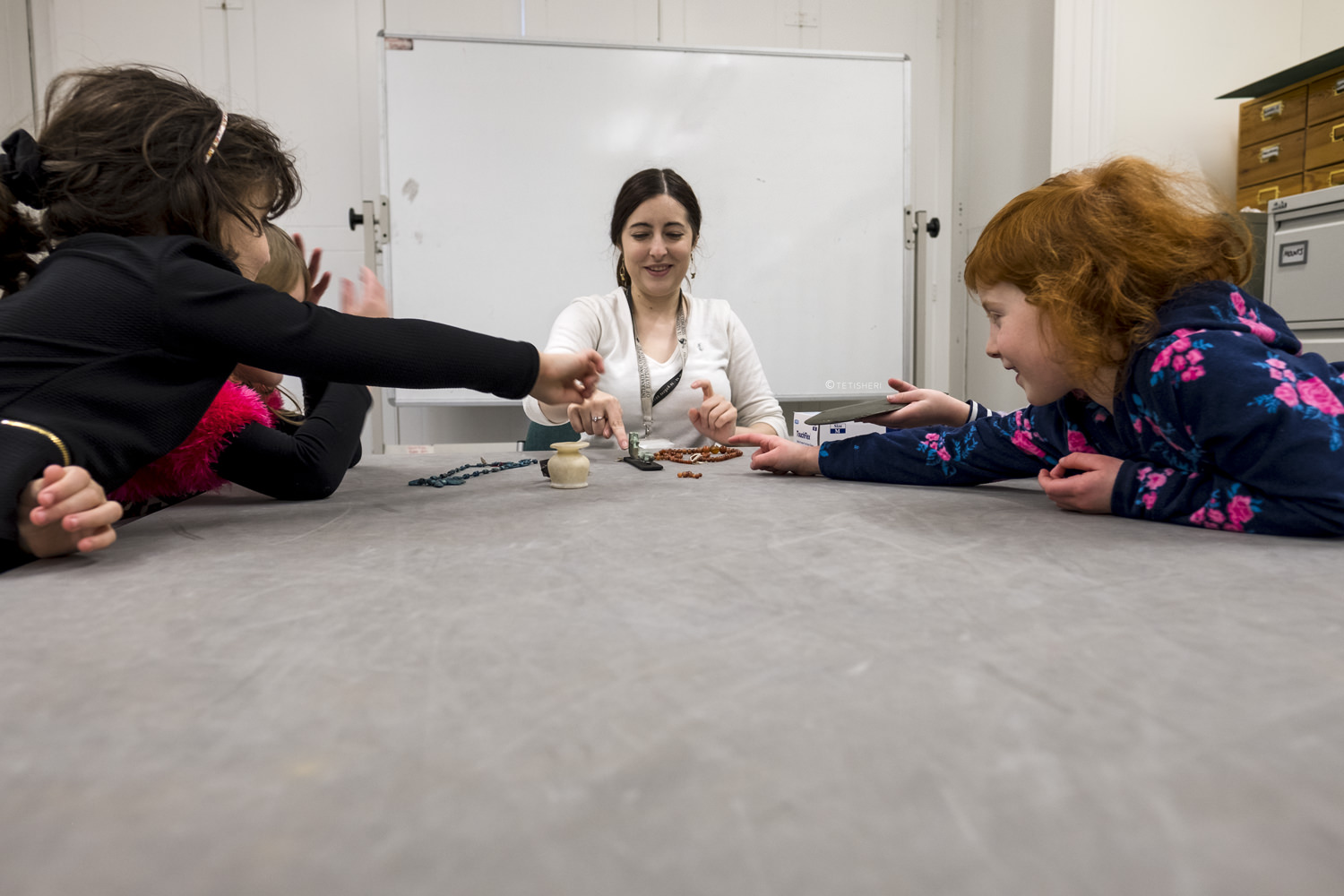 a curator with children looking at egyptian artefacts