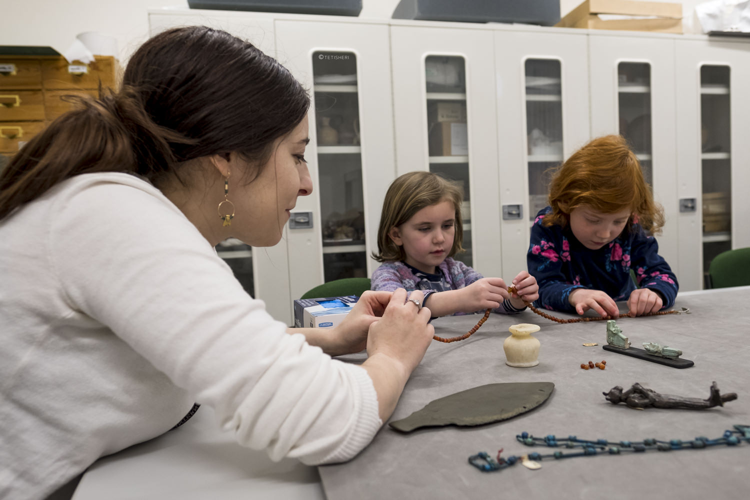 a curator with children looking at egyptian artefacts