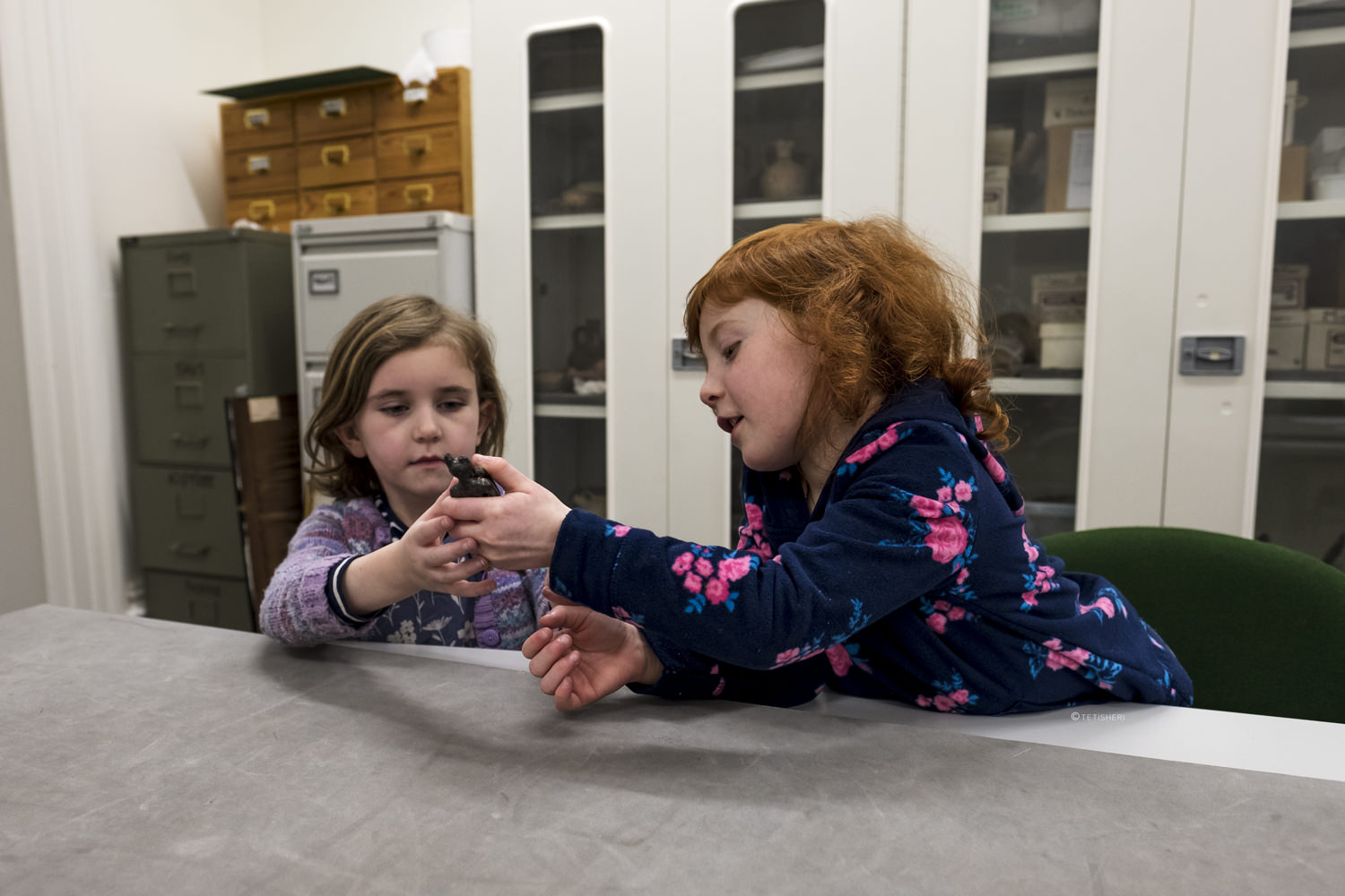 two girls looking at an egyptian artefact