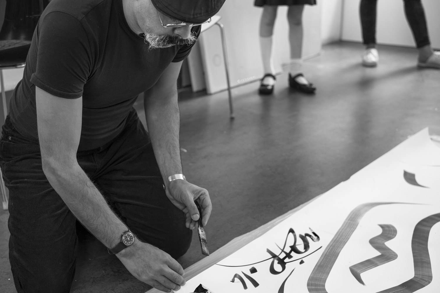 nazir tanbouli signing a piece of his art