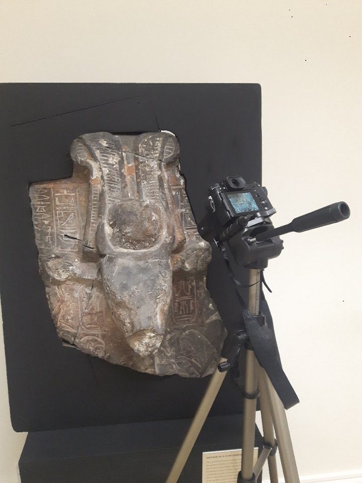 a camera on a tripod photographing a statue of the egyptian goddess hathor