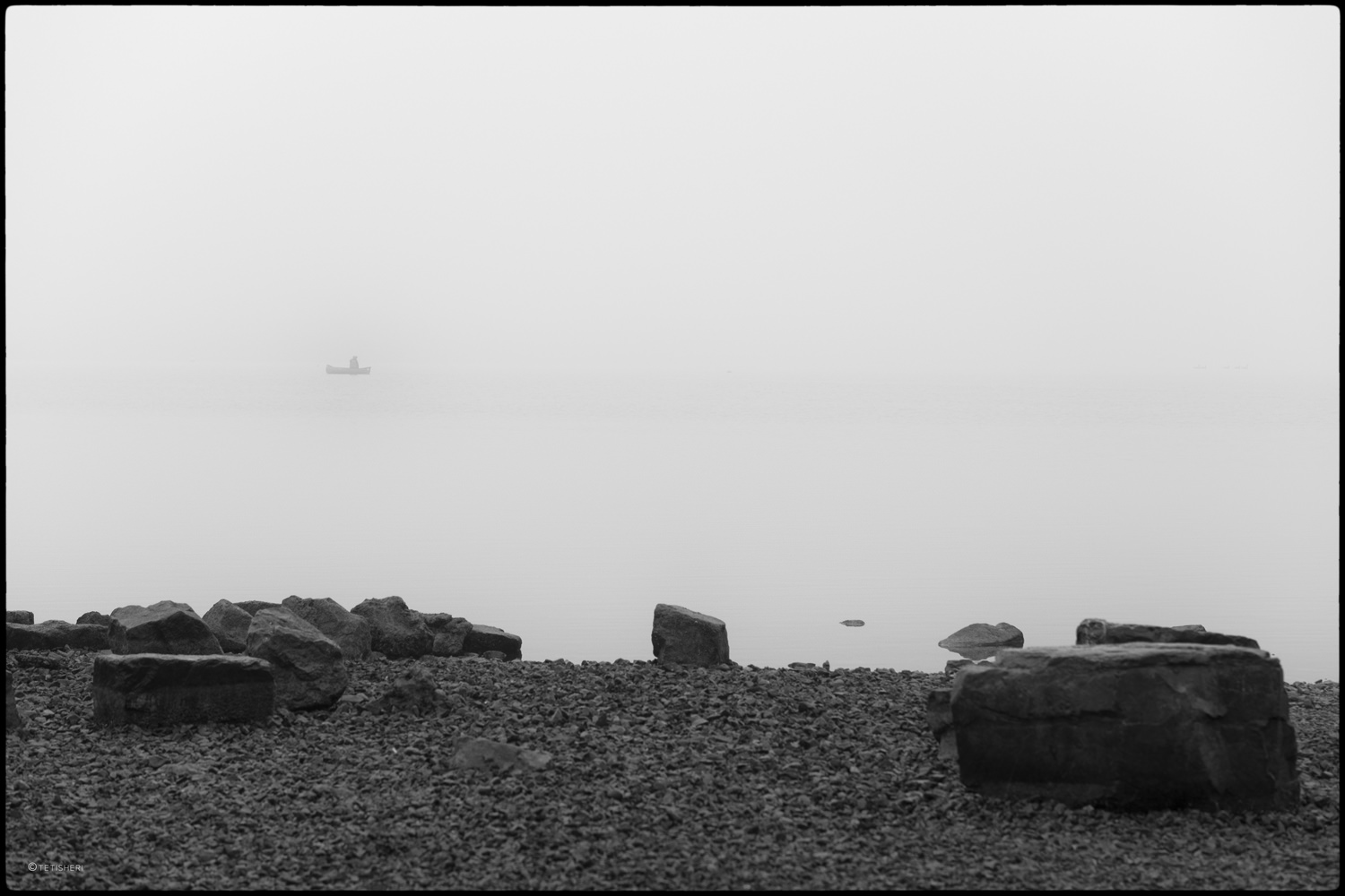 a small boat on a lake shrouded in fog