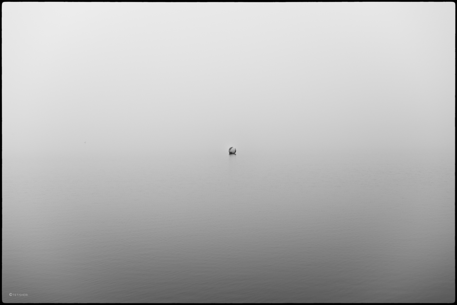 a buoy on a lake shrouded in fog