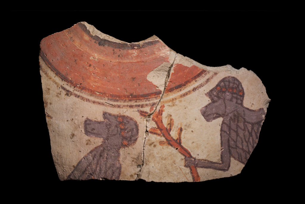 A fragment from a ceramic vessel featuring painted baboons, one holding a branch, and a red-painted rim.