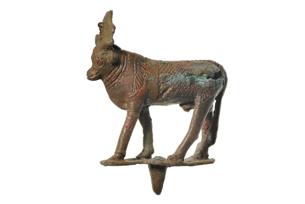 A bronze statuette of a bull with a headdress.