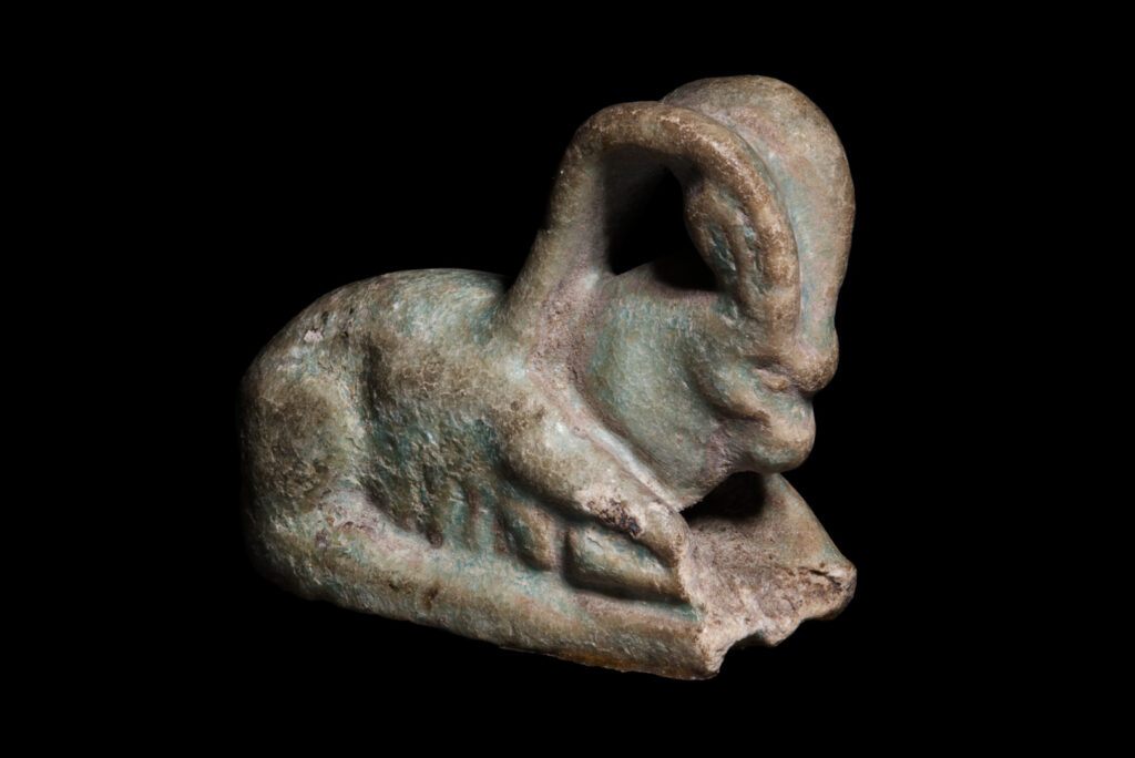 An ancient Egyptian amulet of a recumbant ibex.