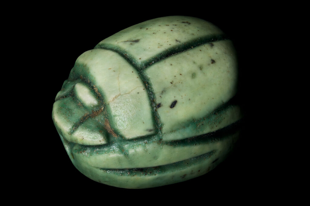 A small green faience scarab beetle.